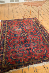Corner of vintage Dargezine rug, red and indigo herati pattern, visible wear, tattered fringe.