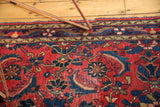 Detail of Vintage Dargezine rug, red field, indigo herati leaves, and areas of pile wear.