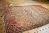 Antique Zuli Sultan rug corner with worn border, red, saffron, and navy floral lattice.