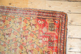 Tattered corner of antique Zuli Sultan rug showing red border and saffron floral lattice.