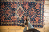 Vintage Baktiari rug featuring triple medallions, navy blue, terracotta, and even wear.