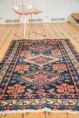 Angled detail of vintage Baktiari rug with navy, terra cotta Laleh Abassi border.