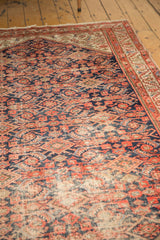 Localized wear exposing foundation within the vintage Malayer rug's Herati motif.