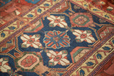 Detail of antique Kurdish rug fragment: Mina Khani floral pattern with historic wear in navy blue, red, and ivory.