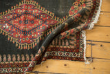 Antique Persian Senneh rug border detail with madder red boteh and tattered fringe.