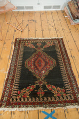 Senneh rug corner: madder red floral bouquet, boteh border, tattered fringe.