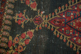 Madder red floral and boteh motifs with sky blue accents on dark field of antique Senneh rug.