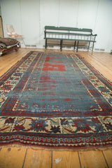 Close view of an antique Kazak runner's lightly tattered fringe and sharp, serrated geometric border.
