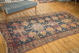 Antique Soumac rug detail: indigo blue field, geometric motifs, visible wear, exposed foundation.
