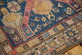 Antique Soumac rug showing geometric borders and starbursts in indigo, cherry red, and dusty gold.