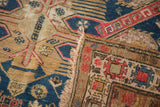 Intricate geometric Soumac patterns with textural wear in navy, red, and gold.