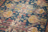 Hand-woven geometric patterns and aged patina in indigo, gold, and red on this antique Soumac rug.