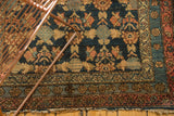 Antique Malayer rug corner highlighting intricate tree motif, blossom borders, and frayed end.