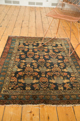 Antique Malayer rug detail: navy blue tree-shrub lattice, raspberry lotus borders, and fringed end.