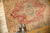 Antique Kaisary rug's worn central medallion, featuring wine red, gold, and visible foundation.