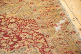 Localized wear revealing foundation with wine red floral details on an antique Kaisary rug.