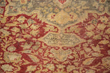 Antique Kaisary rug's cartouche featuring vinery and floral motifs in wine red, gold, and silver.