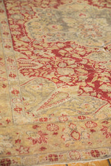 Antique Kaisary rug detail: wine red vinery, dusty gold field, elongated boteh, and visible wear.