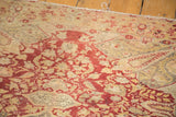 Antique Kaisary rug close-up, highlighting wine red floral patterns, aged beige, and visible pile wear.