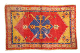Vintage Oushak rug with oversized blue medallion, cherry red field, and saffron yellow tendrils.