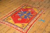Oushak rug's yellow border with serrated contour, tangerine florals, and tattered fringe.