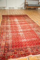 Antique Persian Malayer runner showcasing bright red Mir boteh pattern and visible wear.