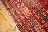 Antique Persian Malayer runner border, red, orange starburst design, visible wear.