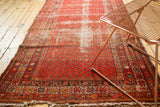 Antique Malayer runner corner featuring stylized starburst border and areas of foundation wear.