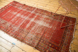 Worn corner of antique Malayer rug runner, revealing foundation and stylized border design.