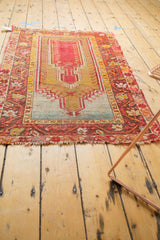 Worn bottom fringe and border of antique Mudjur rug with red and gold tones.