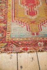 Aged edge and geometric border of the antique Mudjur rug, featuring rich red and golden patterns.