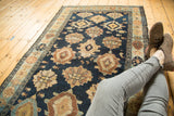Detail of antique Malayer runner: indigo field with column of gold and brown medallions, minor knot wear.