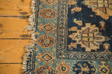 Antique Malayer rug with tattered fringe, teal border, and indigo blue field patterns.