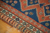 Stepped contouring of madder red and indigo blue field, intricate geometric border, and tattered rug edge.