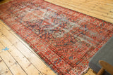 Antique Malayer runner end featuring a worn indigo field, henna plant motif, and tattered fringe.