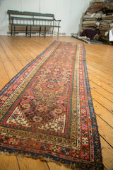 Antique Karabagh runner with colorful Herati pattern on charcoal brown field, showing tattered ends.