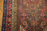 Worn border and etched Herati pattern on the antique Karabagh runner's charcoal field.