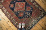 Afshar antique rug: navy diamond and hook motifs, intricate red geometric border.