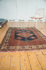 Tattered end fringe and geometric border motifs on the antique Afshar rug, featuring rich pomegranate red.
