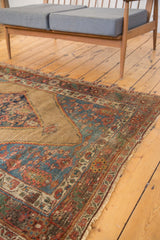 Antique Bijar rug corner with natural camel hair field, serrated tribal rendering, and detailed borders.