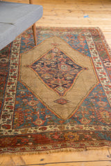 Antique Bijar rug: detail of serrated tribal border in madder red, navy blue, and secured ivory fringe.