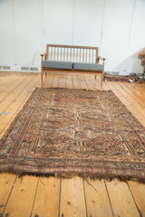 Tattered ends and worn pile texture of an antique Kamseh rug with even wear.