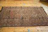 Antique Kamseh rug detail showing pomegranate motifs, even wear, and tattered fringe.