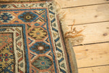 Tattered fringe and worn geometric border of this antique Kurdish carpet.