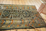 Geometric triple medallions and intricate borders on an antique Caucasian rug, showing threadbare areas.