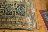 Right edge of this antique Caucasian rug, showing historical wear, exposed foundation, and geometric borders.