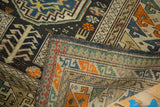 Hand-knotted reverse weave and geometric border of an antique Caucasian rug in tangerine, mallard green, and ivory.