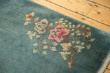 Corner of a vintage Nichols Art Deco rug with secured selvage and rose floral bouquet.