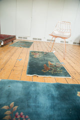Diagonally oriented floral bouquets in rose and tangerine on dusty blue Art Deco rugs.