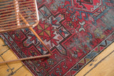Karaja rug corner with worn, unsecured edge and geometric red, blue, ivory motifs.